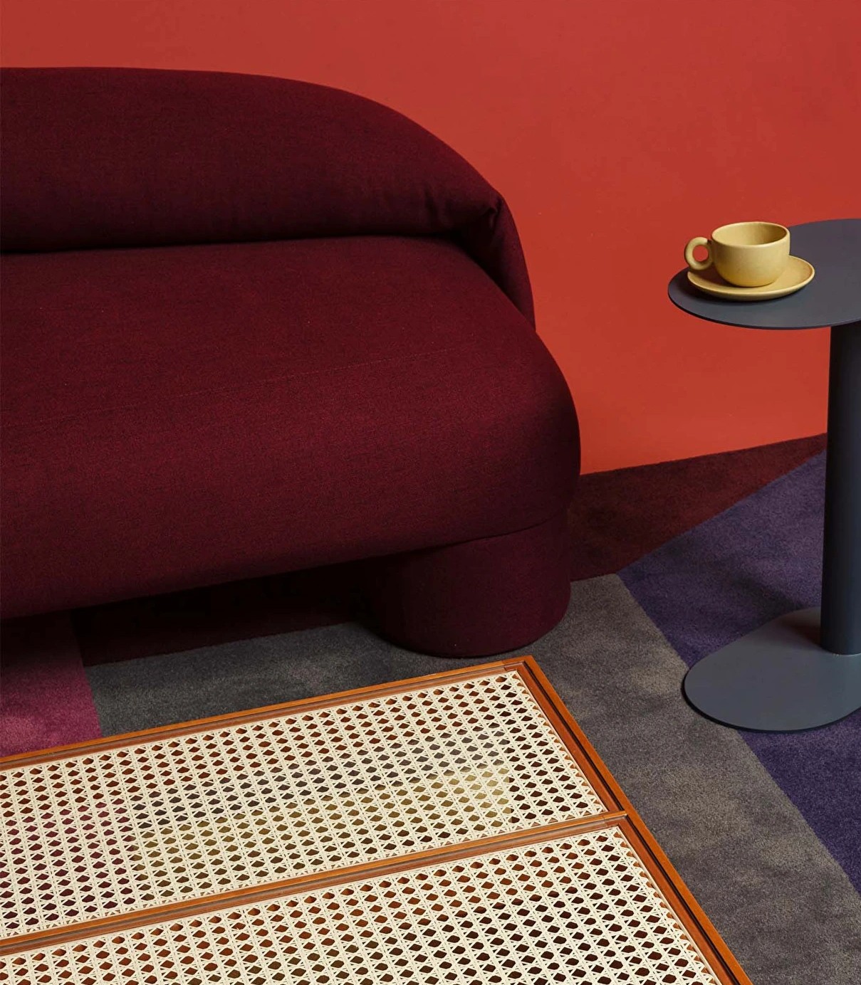 Bold Sofa in burgundy with side table and cane detail